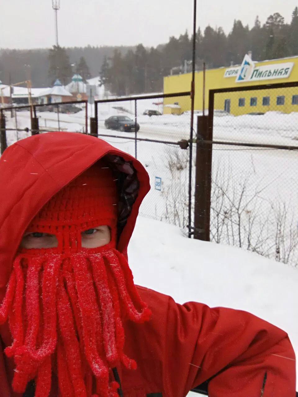 Red octopus knit hat in the snow at a ski hill