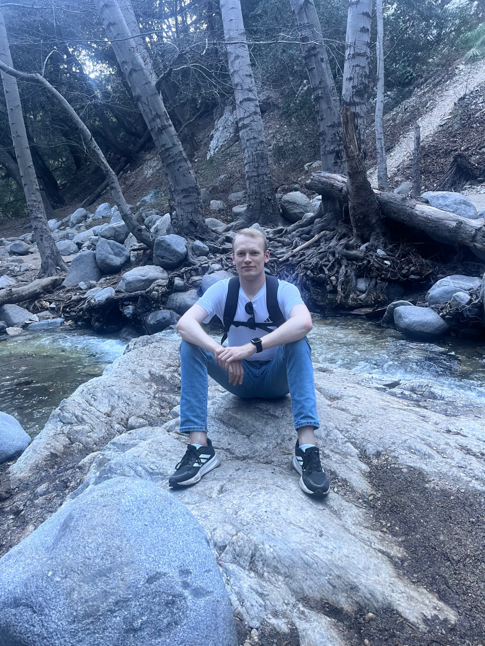 Sitting on a boulder by a mountain creek